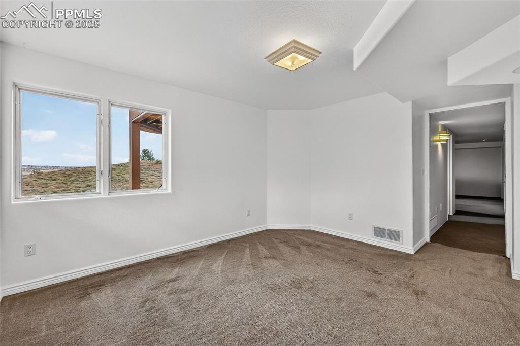 Image 43 of 50: Carpeted room with baseboards
