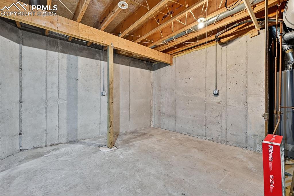 Image 45 of 50: Unfinished below grade area with water heater and large storage space