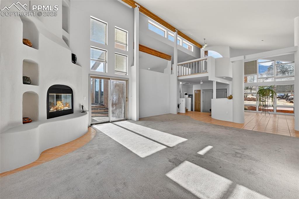 Image 7 of 50: living room with light tile patterned floors, a glass covered fireplace, pl