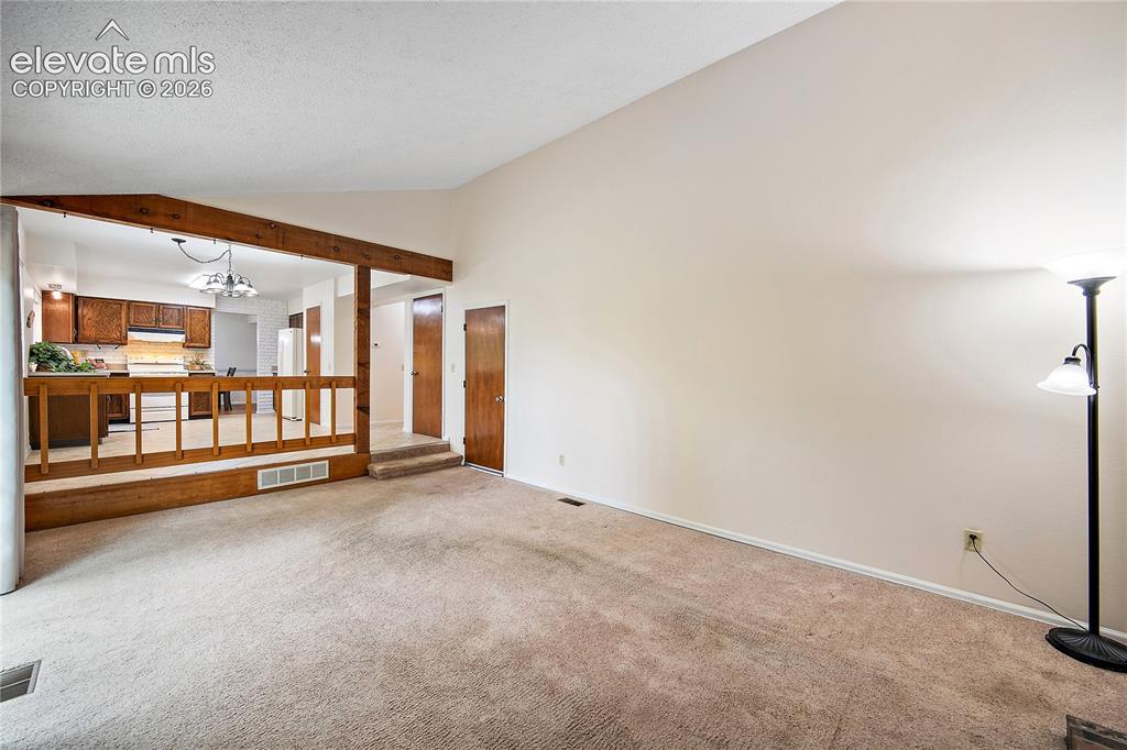 Image 18 of 42: The family room is open and bright with vaulted ceilings and access to the 
