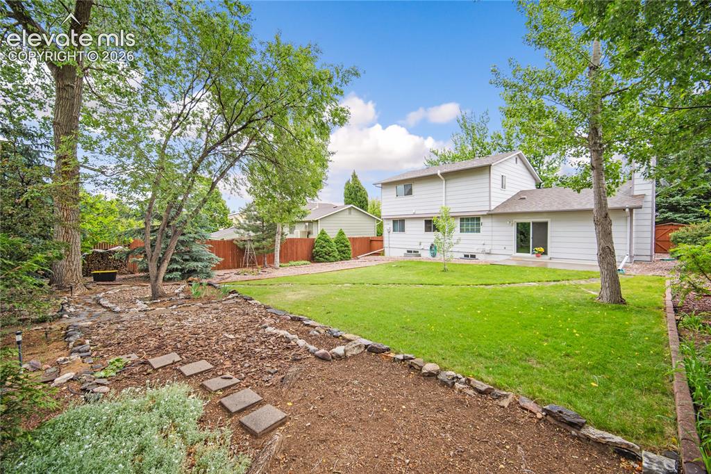 Image 32 of 42: Fully landscaped backyard with mature trees. 