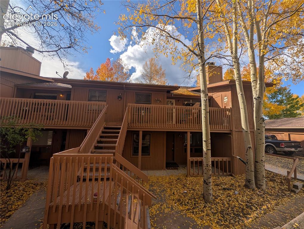Image 2 of 30: Multi-level building exterior featuring wood siding and multiple private de