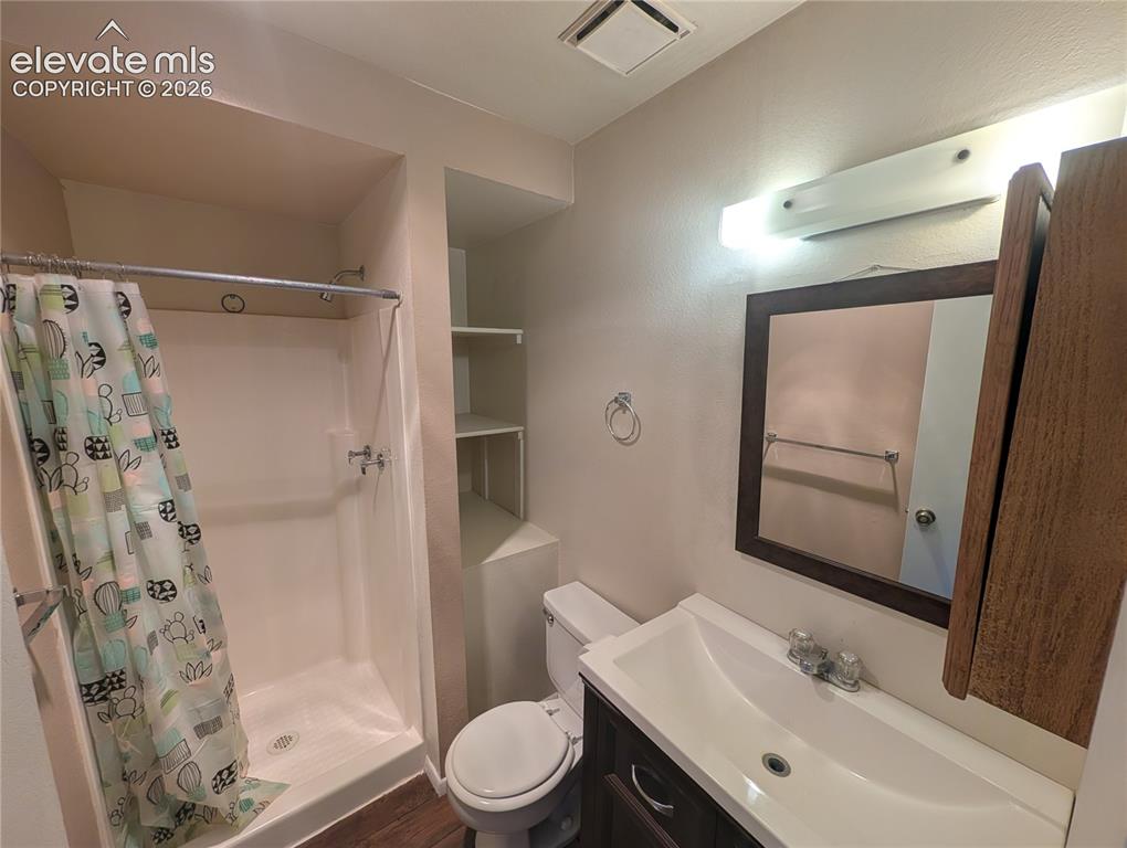 Image 25 of 30: Bathroom featuring a vanity with an integrated sink, framed wall mirror, bu