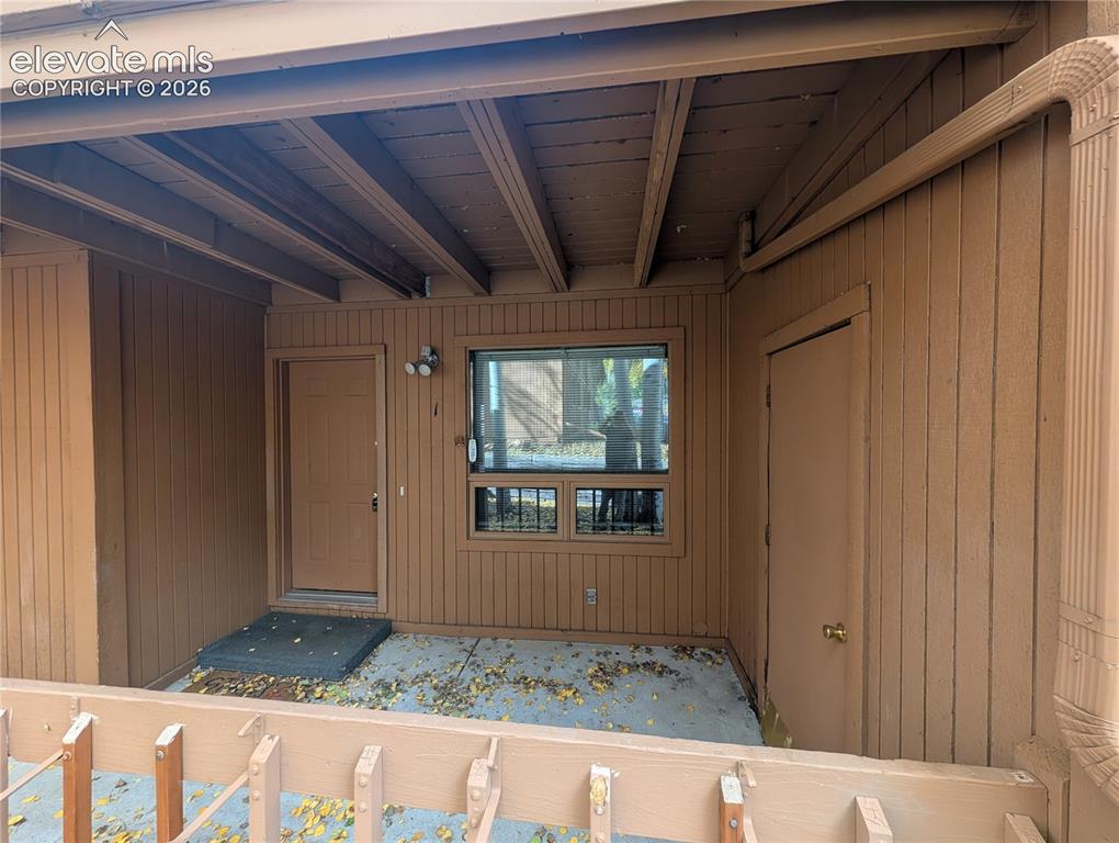 Image 4 of 30: Covered patio featuring a solid entry door, a secondary utility door, and a