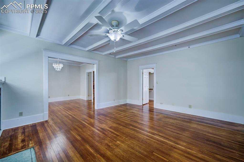 Image 10 of 40: Spare room with a chandelier, dark wood-style flooring, ceiling fan, and be