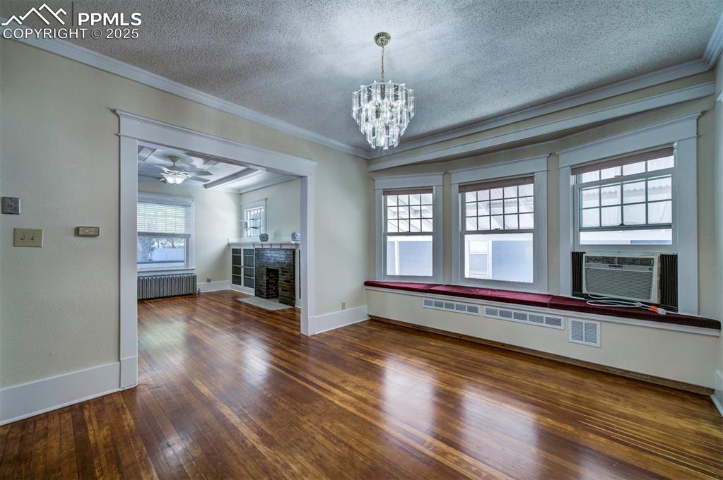 Image 13 of 40: Unfurnished dining area featuring ornamental molding, dark wood finished fl