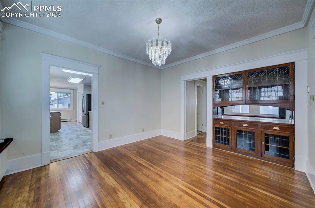 Image 15 of 40: Unfurnished living room featuring a chandelier, dark wood finished floors, 