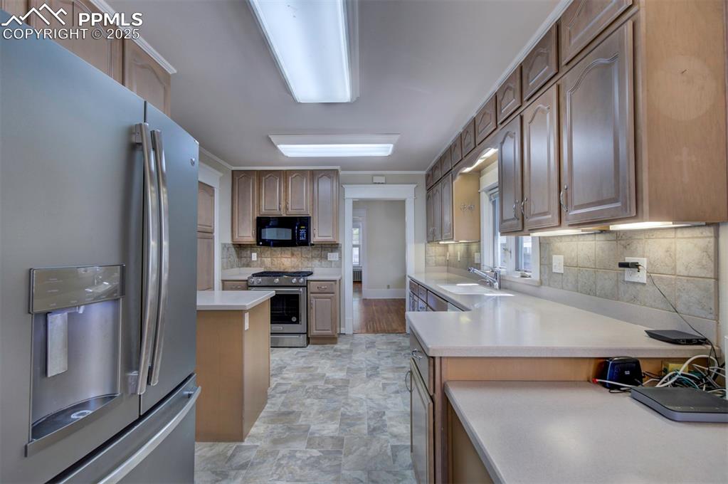 Image 18 of 40: Kitchen featuring appliances with stainless steel finishes, backsplash, sto