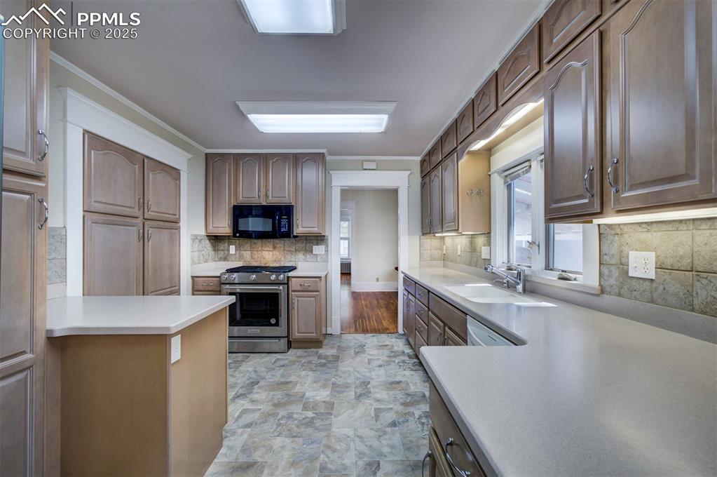 Image 19 of 40: Kitchen featuring appliances with stainless steel finishes, light counterto
