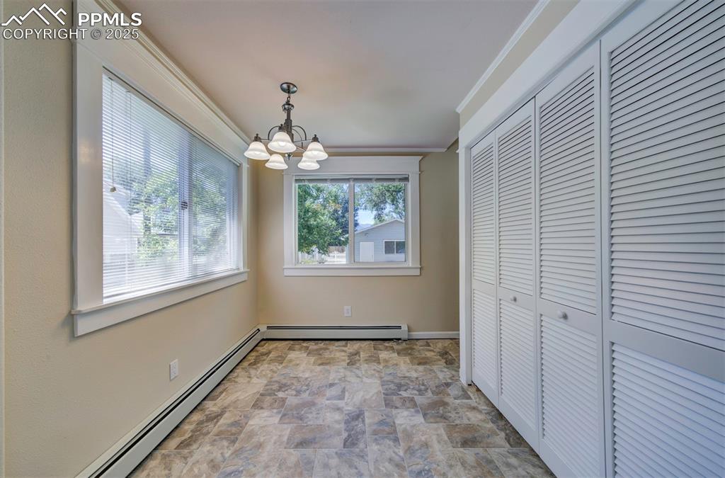 Image 24 of 40: Unfurnished dining area featuring a baseboard radiator, stone finish floori