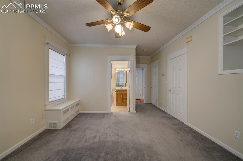 Image 25 of 40: Unfurnished bedroom with carpet, ornamental molding, a textured ceiling, ra