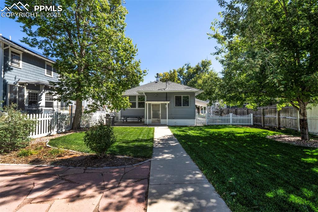 Image 5 of 40: View of back of house with a fenced backyard