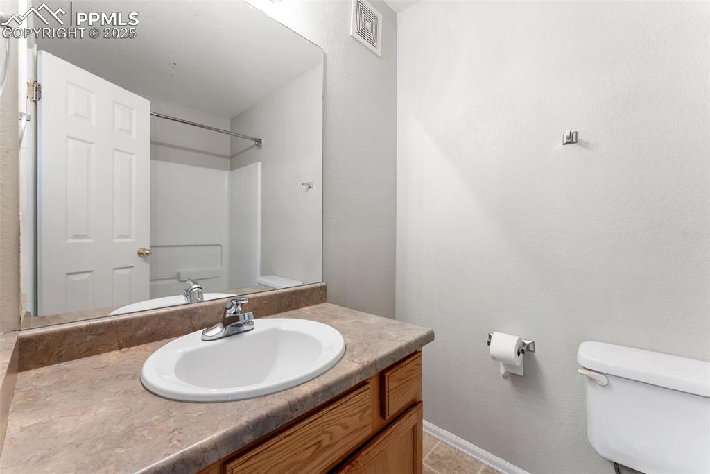Image 19 of 45: Full bath featuring vanity, light tile patterned flooring, and a textured w