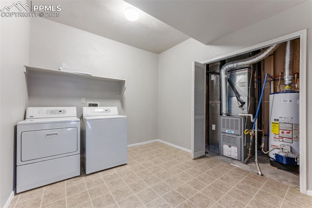 Image 26 of 45: Laundry room with gas water heater, heating unit, and independent washer an