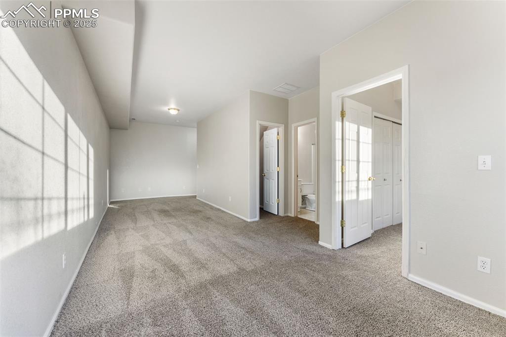 Image 30 of 45: Unfurnished bedroom with light colored carpet and ensuite bath