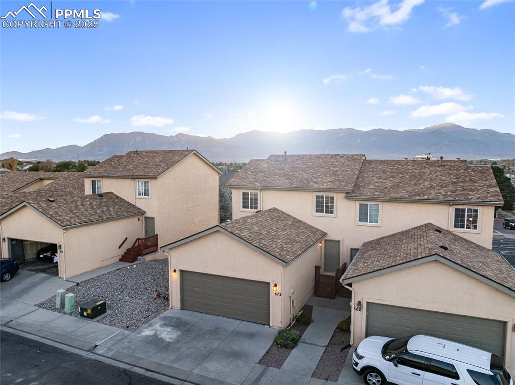 Image 37 of 45: Traditional-style house with stucco siding, a mountain view, concrete drive