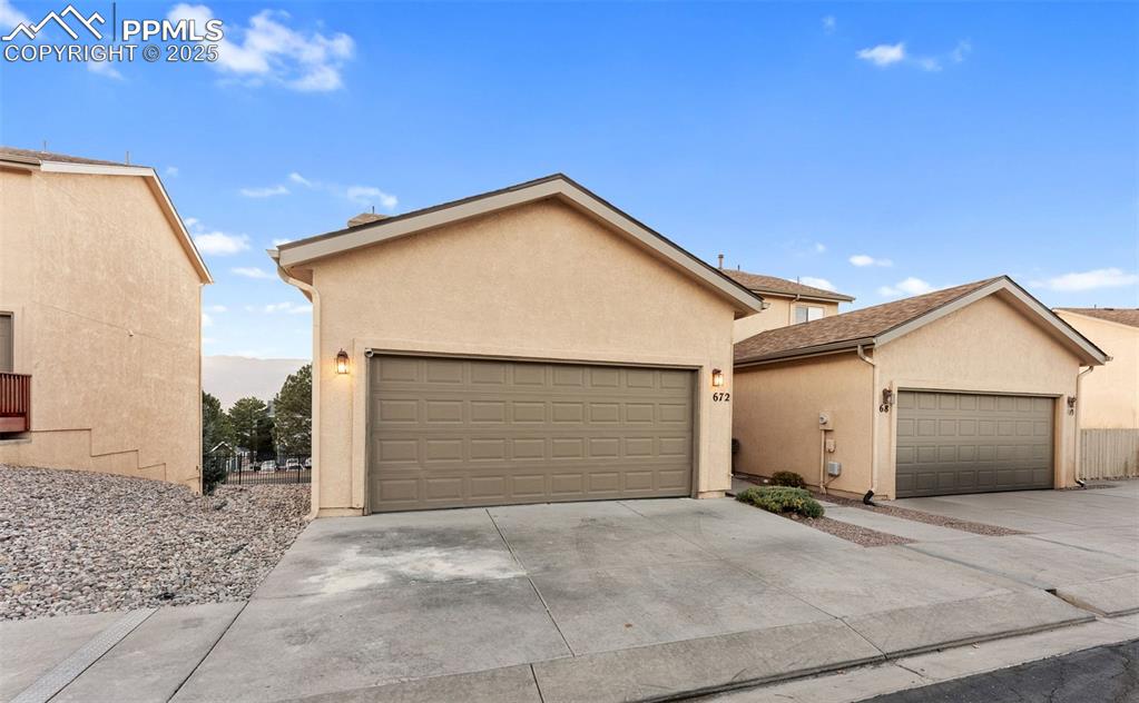 Image 4 of 45: View of front facade featuring stucco siding and concrete driveway