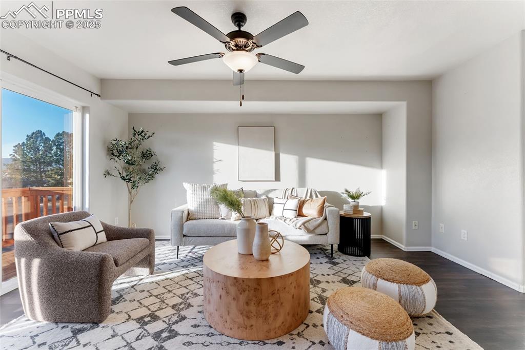 Image 6 of 45: Sitting room with wood finished floors and a ceiling fan