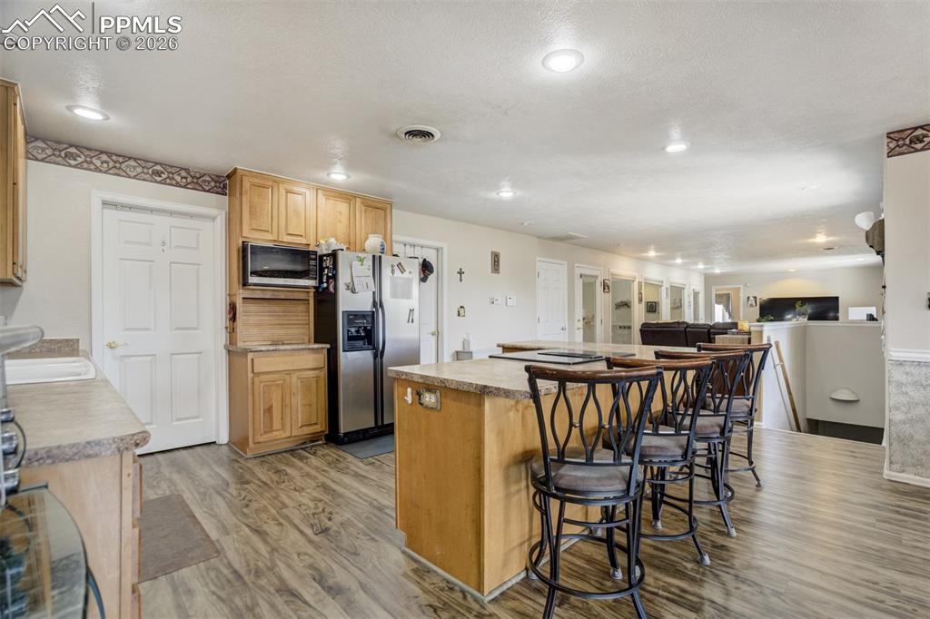 Image 12 of 50: Kitchen with a breakfast bar, and island in an open floor plan