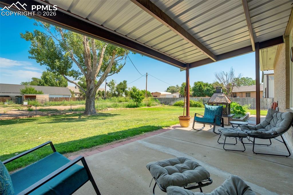 Image 40 of 50: Fenced backyard with a patio area