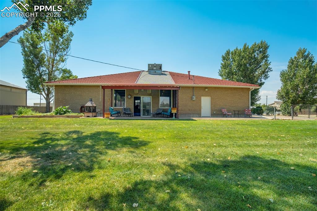 Image 41 of 50: Rear view of house featuring a patio area and brick siding