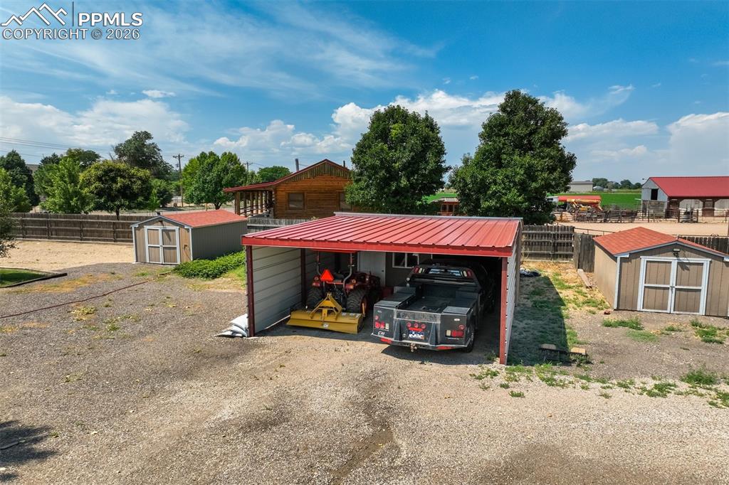 Image 48 of 50: View of workshop attached to carport, and 2 sheds
