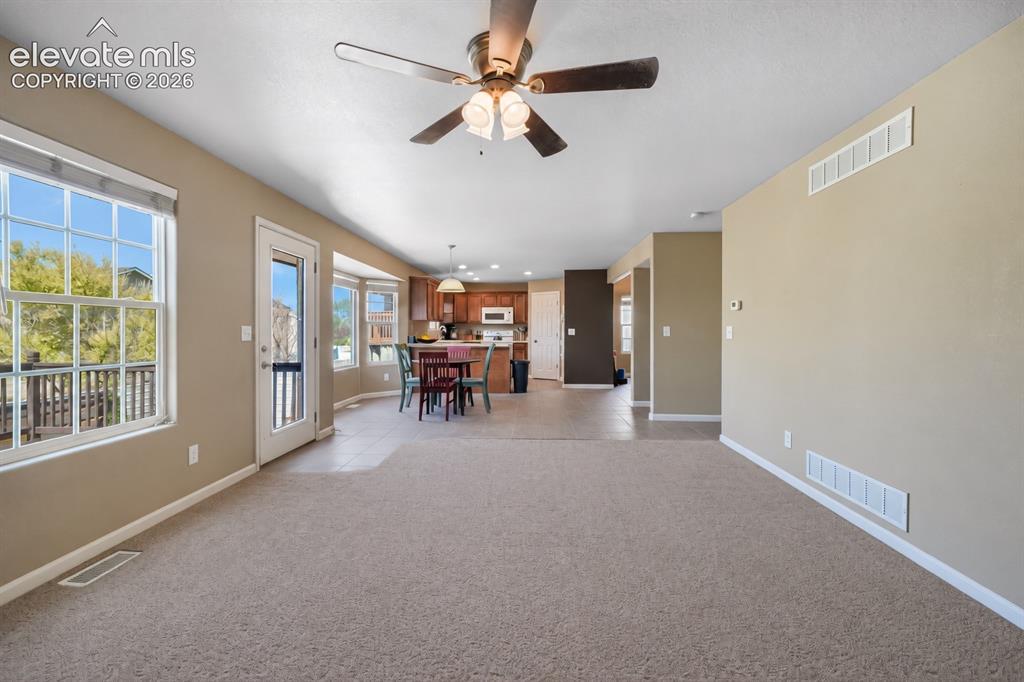 Image 17 of 49: Carpeted living area with a ceiling fan and recessed lighting