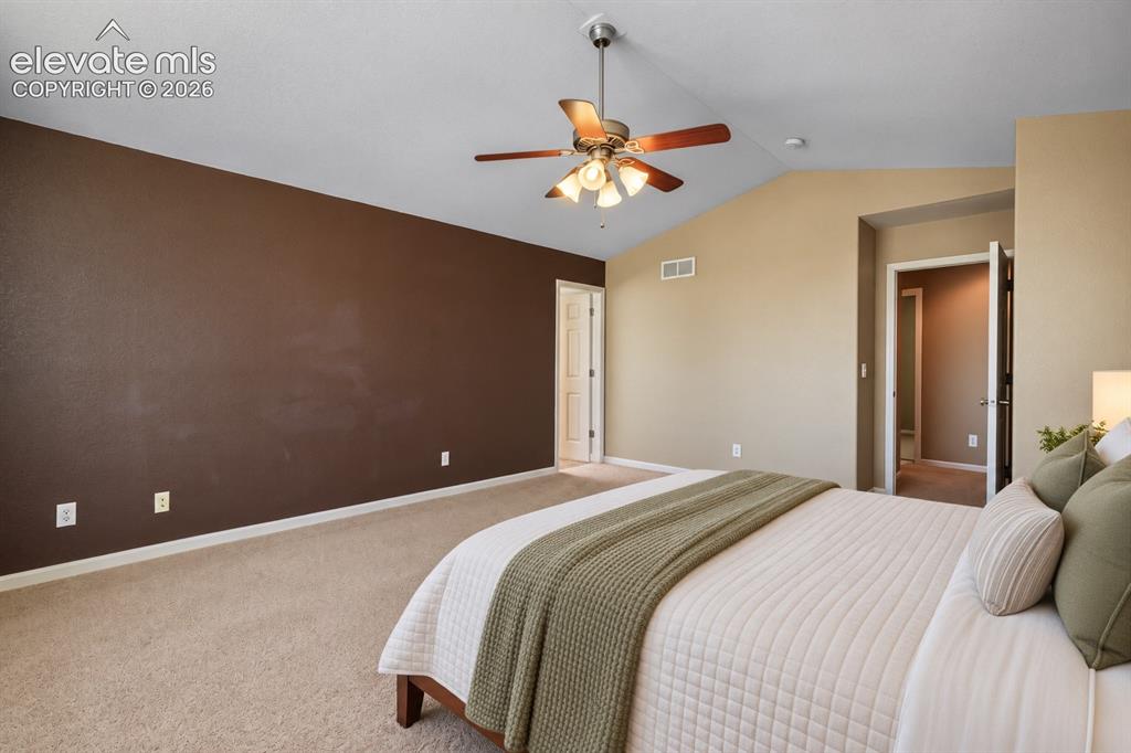 Image 24 of 49: Vaulted ceilings with a ceiling fan, plush carpet, and a neutral color pale