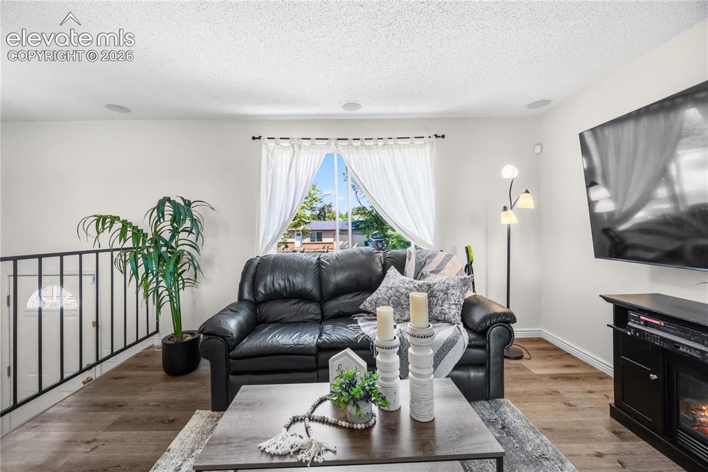 Image 4 of 31: The bright & inviting Living Room showcases an electric portable fireplace,