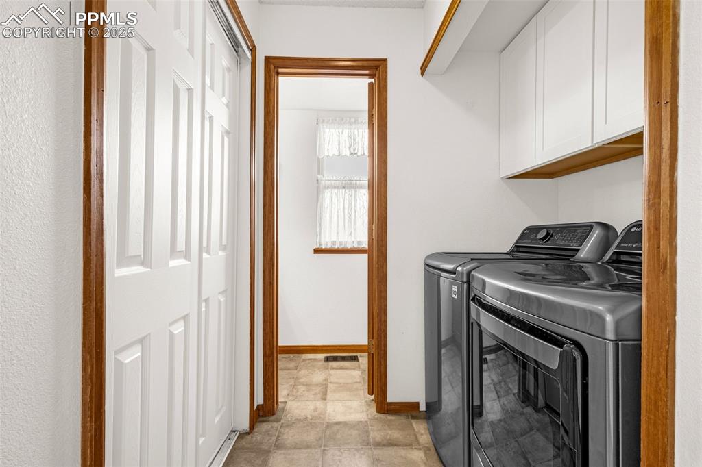Image 10 of 35: Clothes washing area featuring baseboards, washer and clothes dryer, and ca