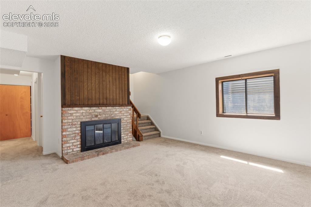 Image 18 of 31: Basement Family Room w/ wood burning fireplace