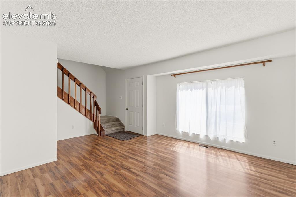 Image 3 of 31: Living Room & Foyer w/ wood laminate flooring
