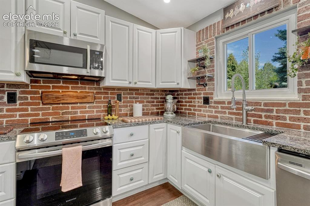 Image 11 of 50: Stainless steel appliances include a smooth top range oven, built-in microw