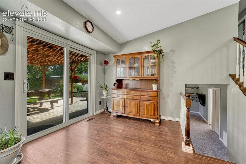 Image 12 of 50: Dining Nook and slider door to the backyard deck with covered pergola.