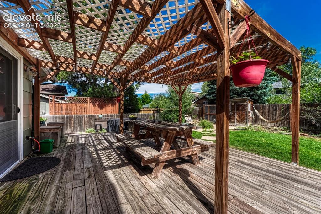 Image 13 of 50: Expansive backyard deck with covered pergola for outdoor dining, entertaini