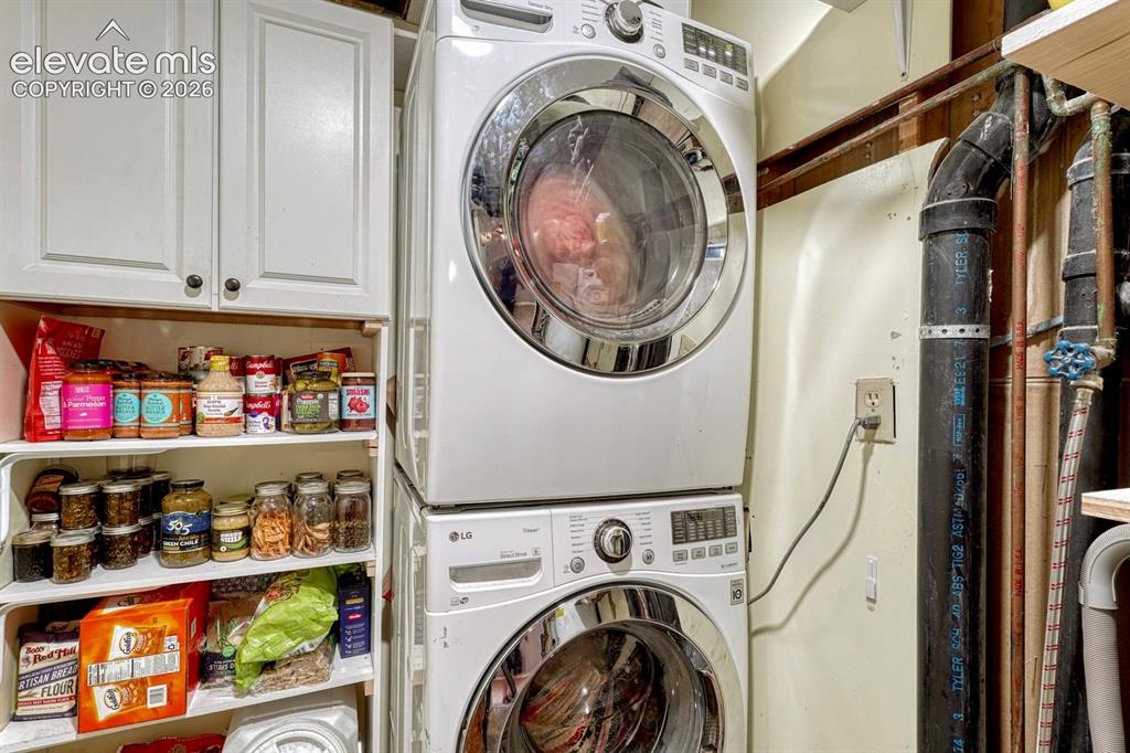 Image 22 of 50: The Laundry Room has storage cabinetry, & the washer & dryer are included. 