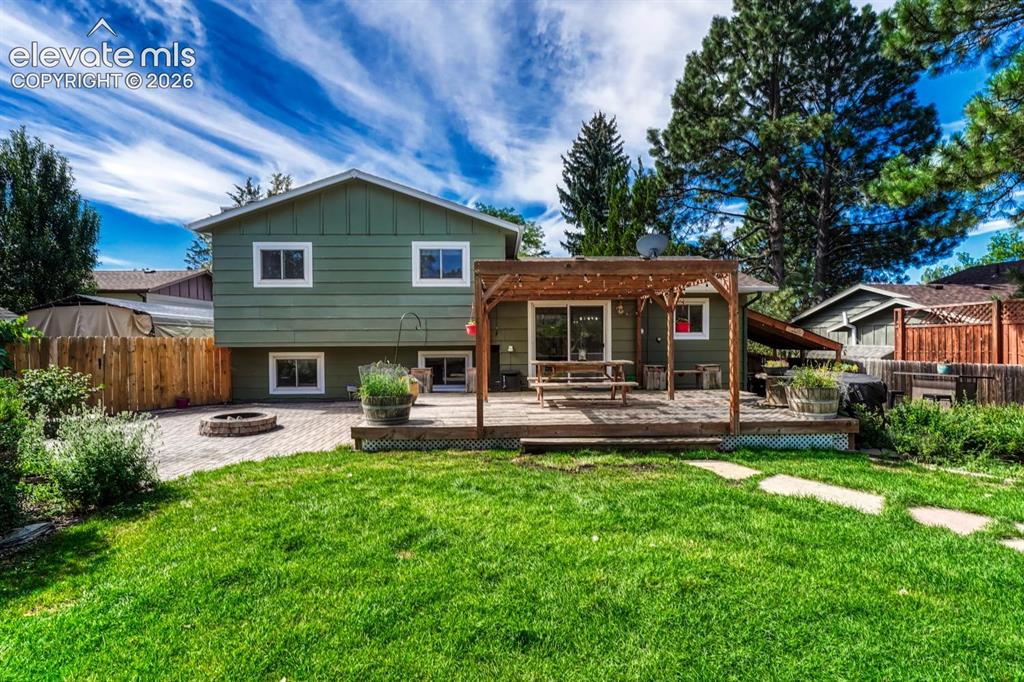 Image 33 of 50: The fenced backyard is a fabulous sanctuary that features mature landscapin