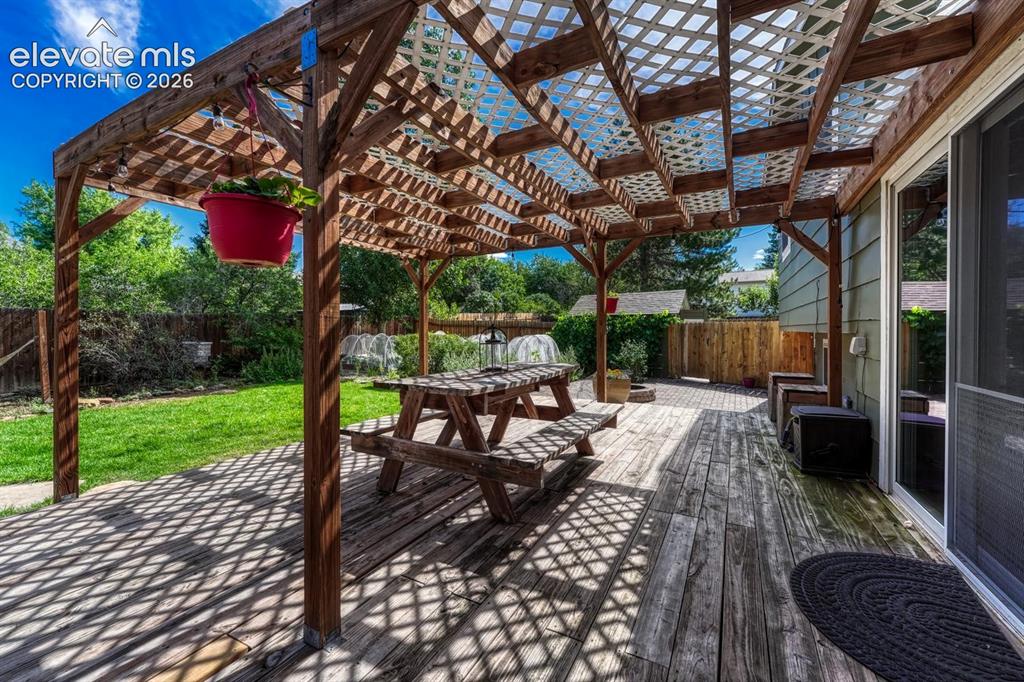 Image 34 of 50: Expansive deck with pergola.