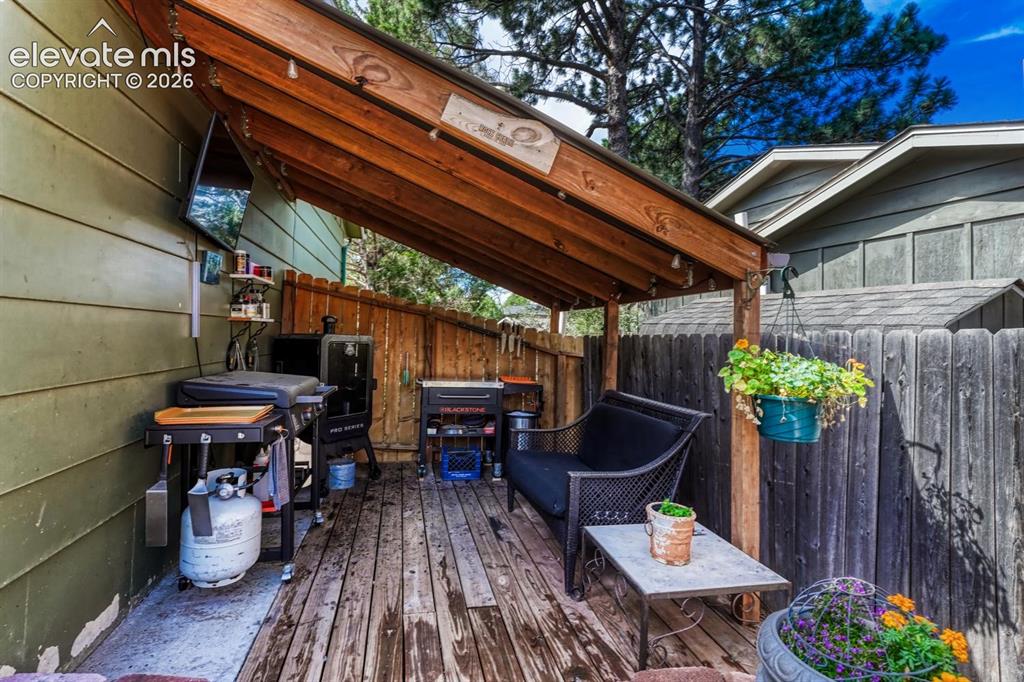 Image 41 of 50: Side covered deck with BBQ area.