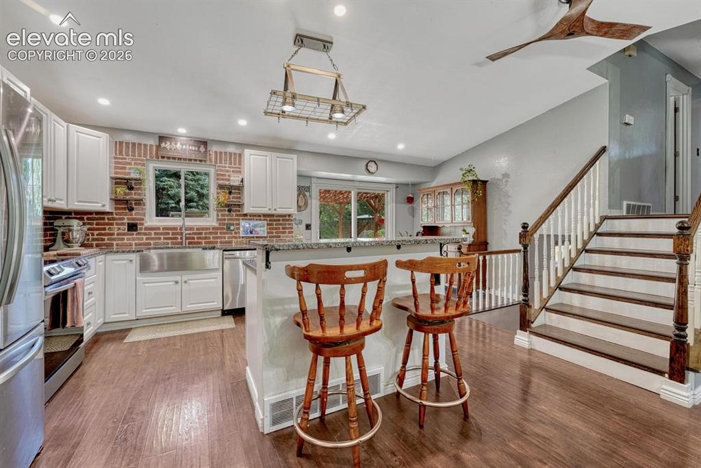 Image 7 of 50: View of Kitchen and stairs to the upper level.