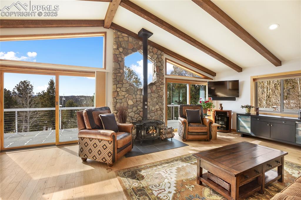 Image 13 of 40: Beautiful beam accents and a beautiful fire to add to the cozy mountain fee