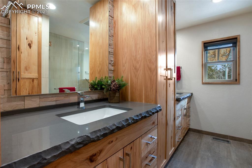 Image 23 of 40: Main Level bathroom with 2 sinks and custom counter