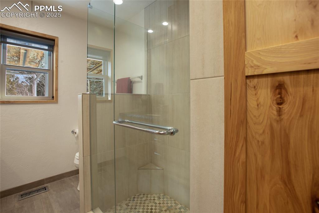 Image 24 of 40: Walk in spa like shower in the main level bathroom