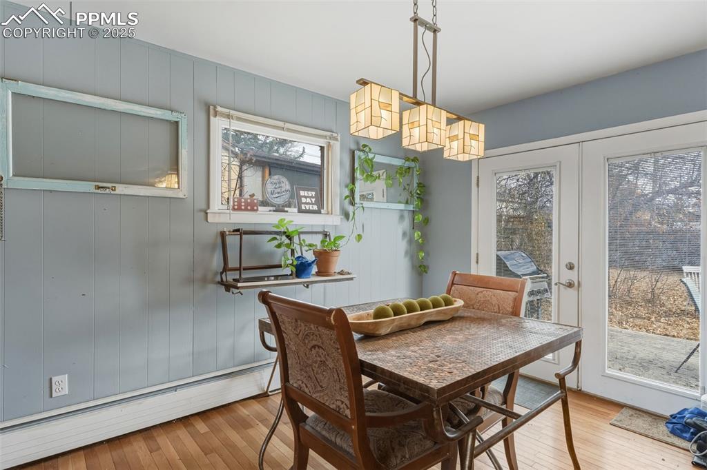 Image 10 of 37: Dining room featuring baseboard heating, wood flooring, french doors.