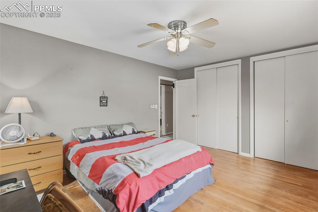 Image 17 of 37: Bedroom featuring multiple closets, wood finished floors, and a ceiling fan
