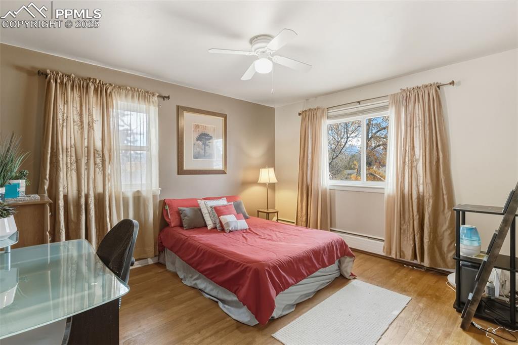 Image 18 of 37: Bedroom with wood finished floors, ceiling fan