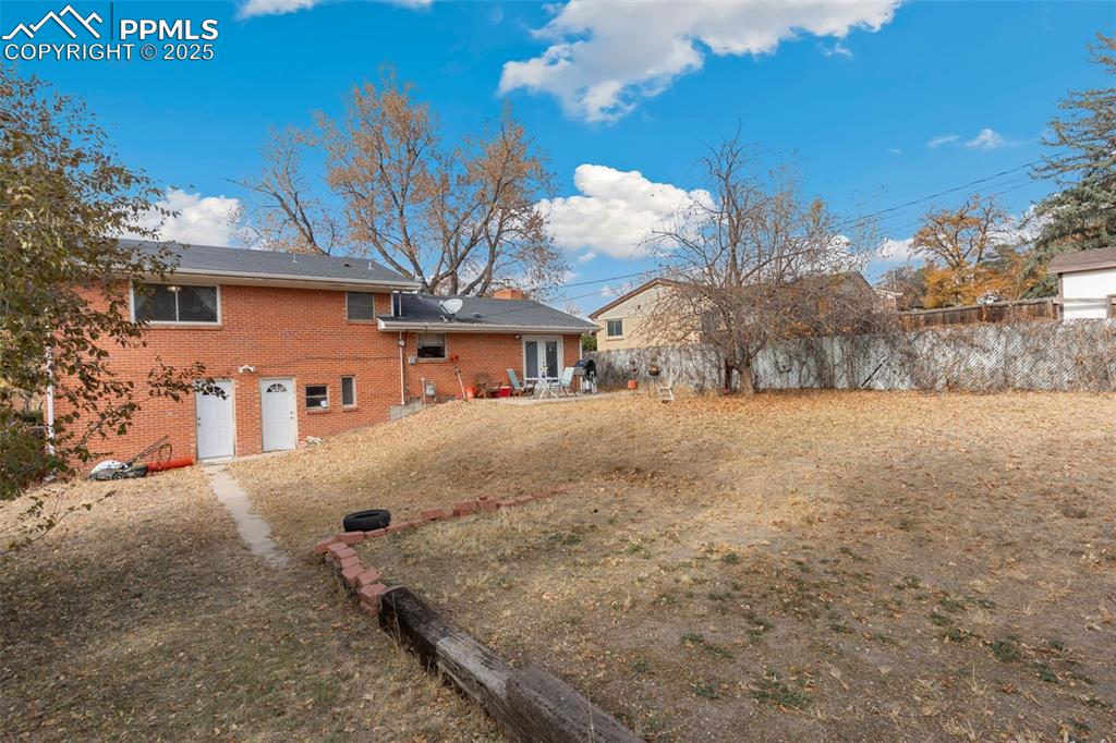 Image 32 of 37: Rear view of property featuring brick siding and a patio