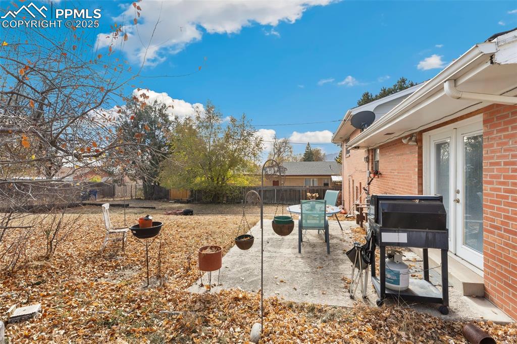 Image 6 of 37: Fenced backyard with a patio