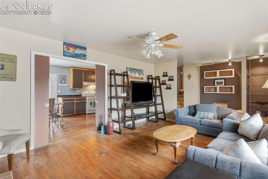 Image 9 of 37: Living area with light wood finished floors and ceiling fan