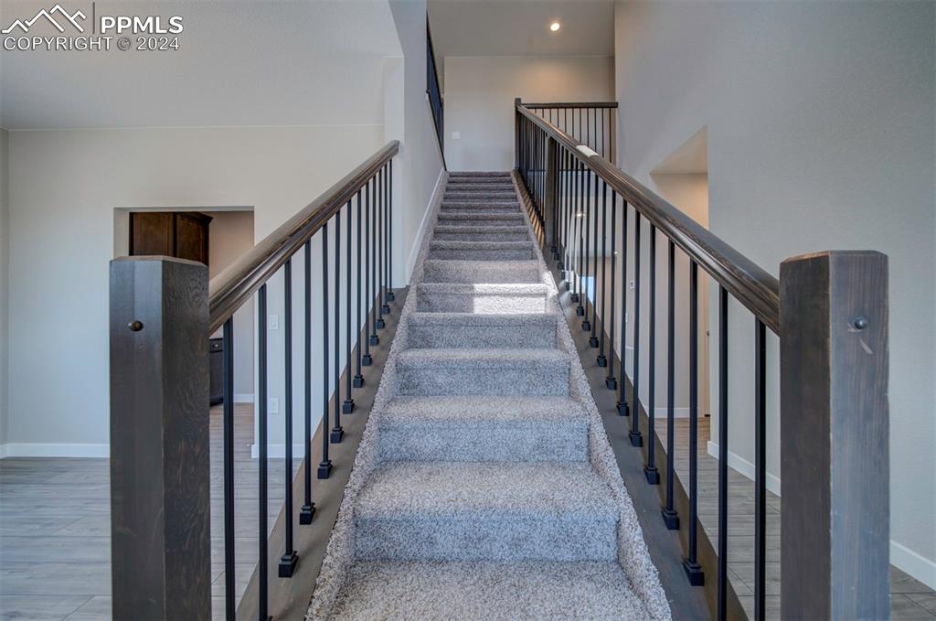 Image 14 of 47: Stairway featuring hardwood / wood-style floors and a high ceiling